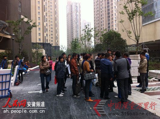 業(yè)主們圍在小區(qū)門口討說(shuō)法。 業(yè)主們圍在小區(qū)門口討說(shuō)法。